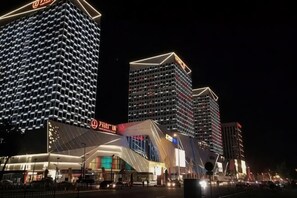 A hotel with a modern facade, multiple floors, and illuminated signage.
