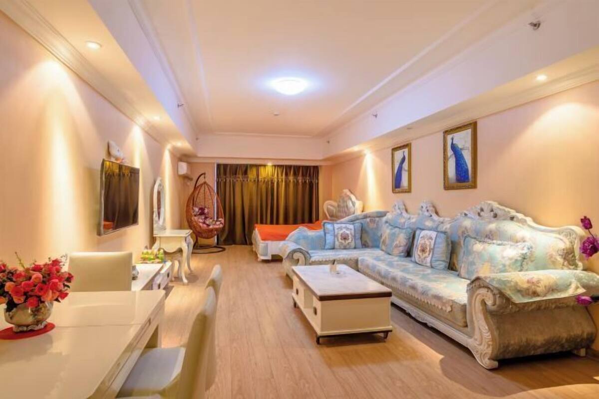 A living room with a sofa, a dining table, and a TV.