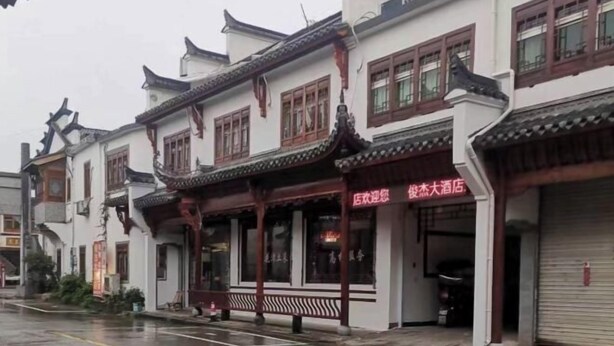 A traditional Chinese building with a closed shutter on the right.