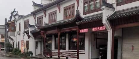 Un edificio tradicional con un vestíbulo cubierto y señalización que indica un restaurante.