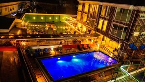 A swimming pool surrounded by a covered area with seating and a bar.