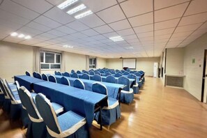 A conference room with rows of tables and chairs, a projector screen, and a large window. - Super 8 Hotel (Qitai Tuanjie South Road Branch) (Qitai)