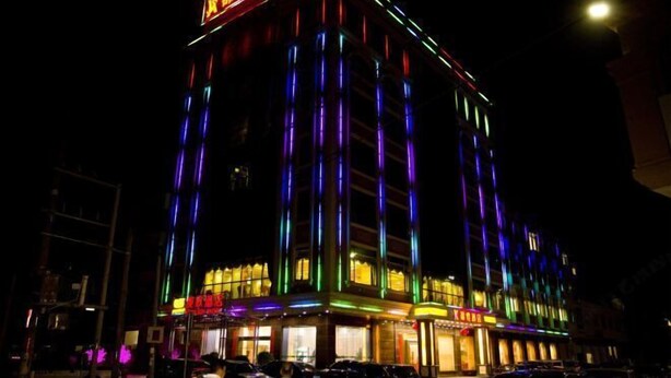 A multi-story hotel with illuminated vertical stripes and a prominent sign at the top. - Boluo Gengxin Hotel (Boluo)