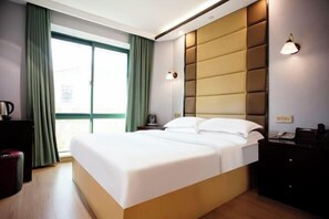 A modern hotel room with a large bed, a bedside table, a nightstand, and a window with curtains. - Changxing Penglaiju Boutique Hotel (Changxing)
