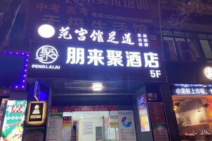 Entrada de hotel con señalización en caracteres chinos, una puerta de acceso visible y un pequeño letrero con información.