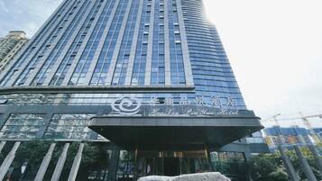 A tall, modern building with a curved facade and a prominent entrance.
