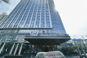 Un edificio alto y moderno con fachada curva y entrada destacada.