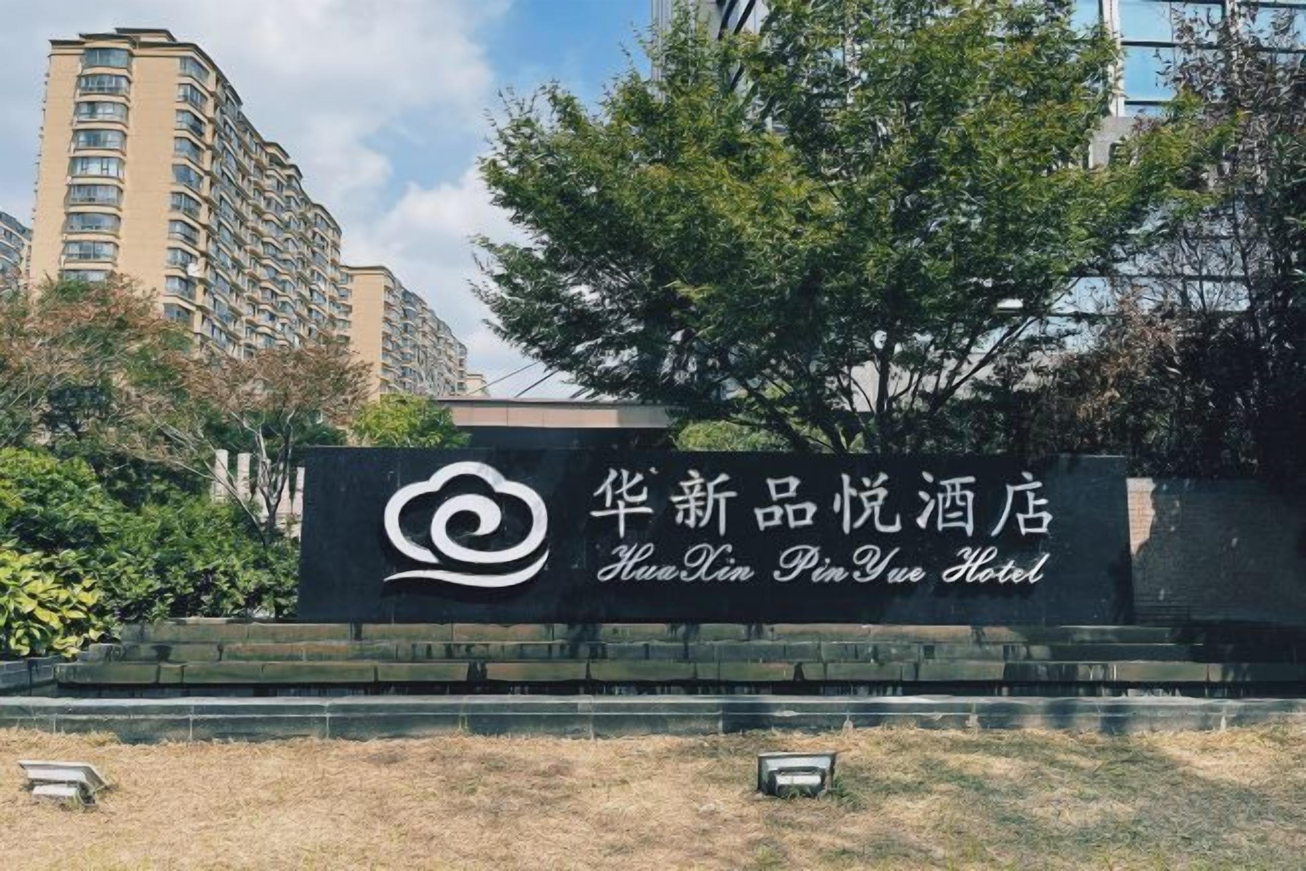 Un letrero de hotel con un logotipo y nombre en caracteres chinos.