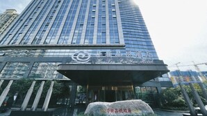 A modern hotel with a curved facade and a prominent entrance.