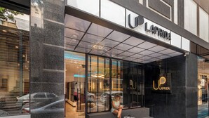 Une devanture moderne avec une entrée en verre, un intérieur visible avec des places assises et une enseigne bien en évidence indiquant « UP LAPRIDA ».