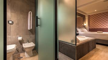 Een moderne badkamer met toilet, bidet en handdoekhouder.