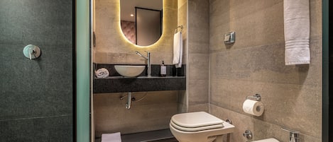 Un baño moderno con lavamanos independiente, inodoro y bidé.