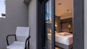 Une chambre d’hôtel moderne, équipée d’un lit, d’une chaise et d’une grande fenêtre.