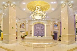 A grand lobby with a large chandelier, marble columns, and a central decorative wall. - Vienna International Hotel (Meizhou Dingzi Bridge) (Meizhou)