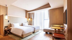 A hotel room with two beds, a desk, a chair, a TV, and a large window with curtains. - Swissotel Hot Spring Hotel Xi'an Xinxing (Xi'an)