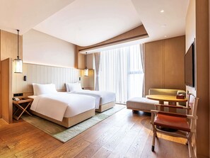 A hotel room with two beds, a desk, a chair, a TV, and a large window with curtains. - Swissotel Hot Spring Hotel Xi'an Xinxing (Xi'an)