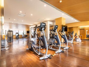 A spacious gym with multiple cardio machines, weightlifting equipment, and a large mirror. - Swissotel Hot Spring Hotel Xi'an Xinxing (Xi'an)