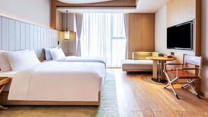 A hotel room with a large bed, a smaller bed, a TV, a desk, and a chair. - Swissotel Hot Spring Hotel Xi'an Xinxing (Xi'an)