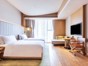 A hotel room with a large bed, a smaller bed, a TV, a desk, and a chair. - Swissotel Hot Spring Hotel Xi'an Xinxing (Xi'an)