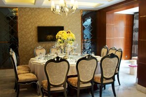 A dining area with a round table, chairs, and a chandelier. - Blossoming Quality Hotel (Xining)