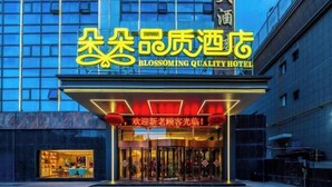 A hotel entrance with illuminated signage and a glass door entrance.