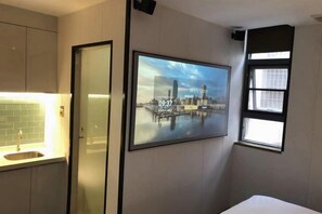 A hotel room with a bed, a wall-mounted TV, a window, and a door. - Tenwood Hotel (Beijing Road Pedestrian Street) (Guangzhou)