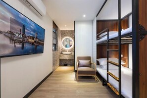 A room with bunk beds, a round mirror, a chair, and a wall-mounted TV displaying a cityscape. - Tenwood Hotel (Beijing Road Pedestrian Street) (Guangzhou)