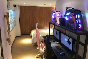 A hotel room with a bed, a desk with a computer, and gaming PCs with RGB lighting. - Tenwood Hotel (Beijing Road Pedestrian Street) (Guangzhou)