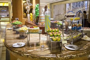 A buffet with various food items and a glass display case. - Jiahua Hotel (Puning)