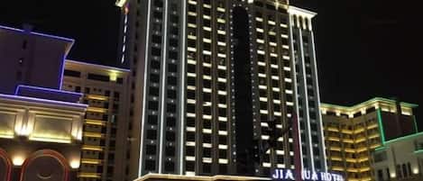 Un hotel de varios pisos con señalización iluminada, una entrada destacada y un diseño arquitectónico moderno.