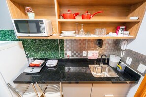 A compact kitchen with a microwave, sink, and a small countertop area. - Life resort (Brasília)