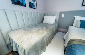 A bedroom with two beds, a padded headboard, and a wall-mounted artwork. - Life resort (Brasília)