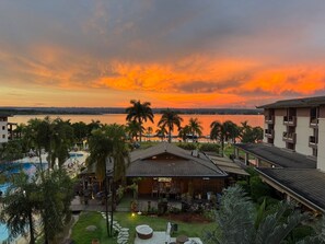 A resort with a pool, a restaurant, and a view of the sunset over water. - Life resort (Brasília)