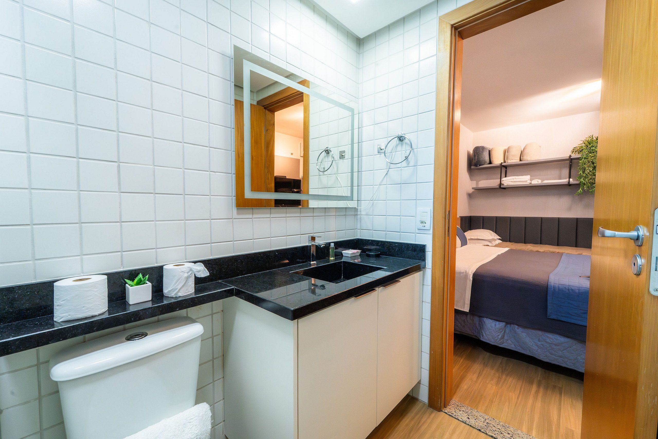 Ein Badezimmer mit Toilette, Waschbecken, Spiegel und Duschbereich.