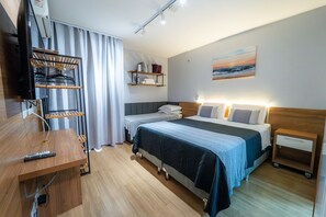 A hotel room with a bed, bedside tables, a TV, a desk, and a shelf with items. - Life resort (Brasília)