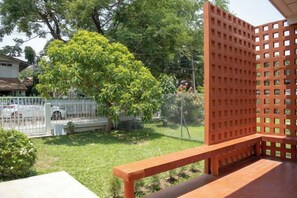 A fenced outdoor area with a bench, a tree, and a white fence in the background. - Ray's Home,3Br with Front Yard,Walkable to Nimman (Chiang Mai)