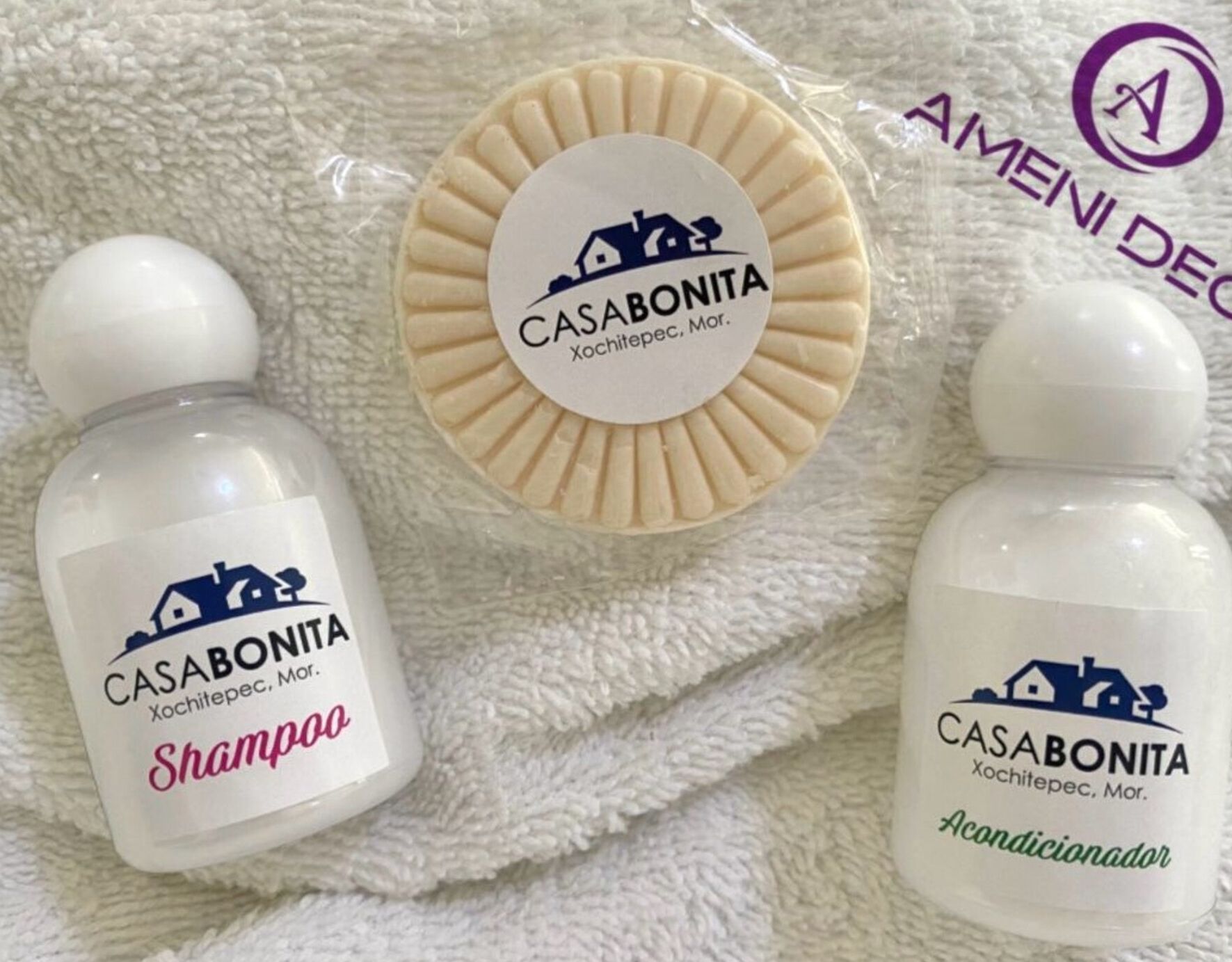 To flasker CASABONITA shampoo og conditioner ligger på et hvidt håndklæde.