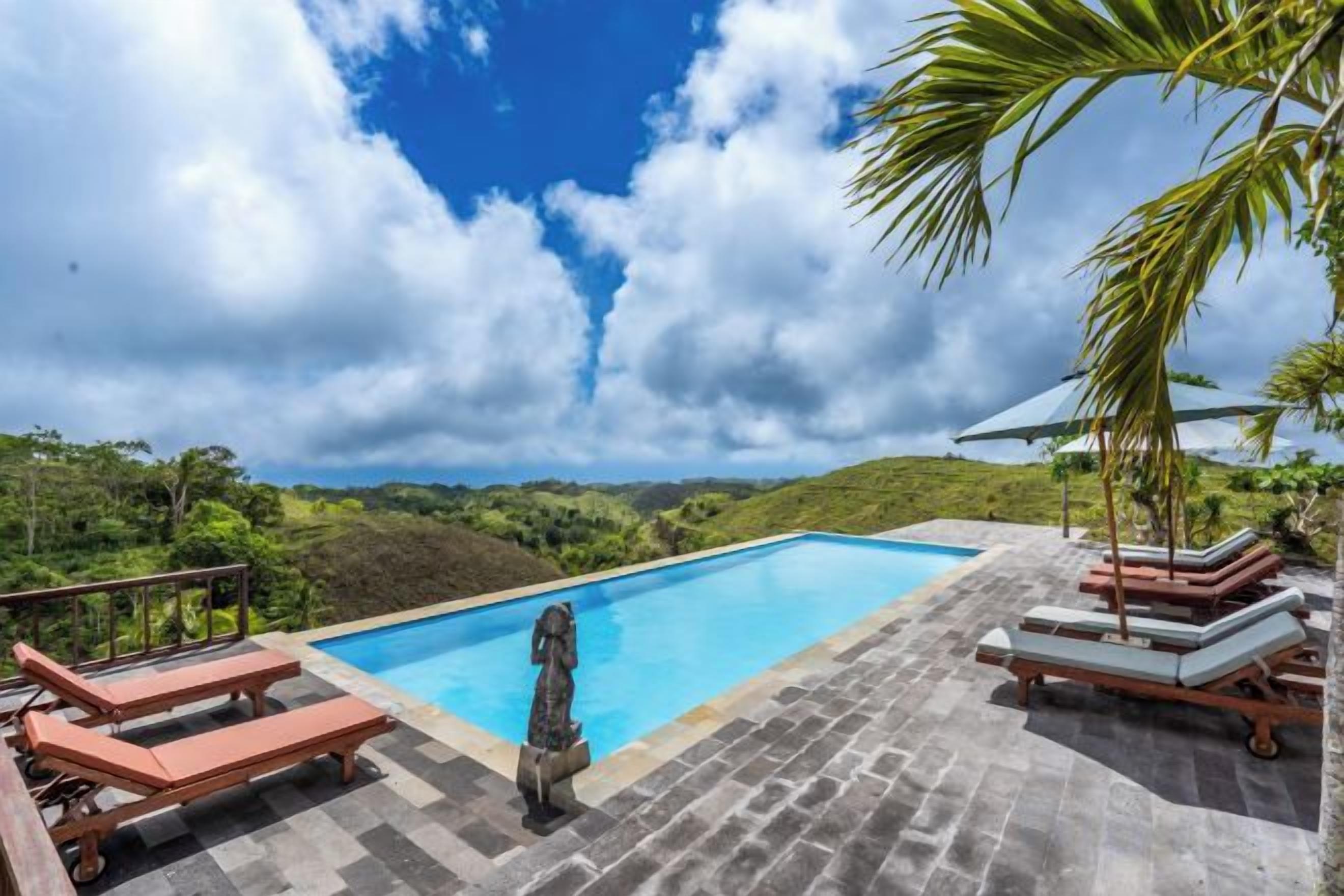 A swimming pool with lounge chairs and a view of the landscape.