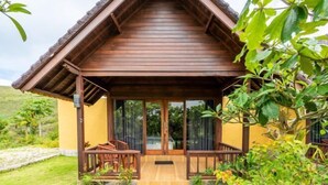 A wooden structure with a porch, glass doors, and a small garden area. - Nusa Penida Pini Sentana (Bali)
