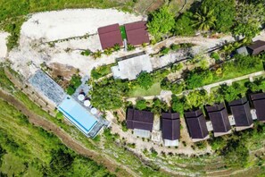 An aerial view of a residential area with multiple houses, a swimming pool, and lush greenery. - Nusa Penida Pini Sentana (Bali)