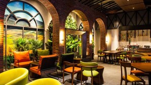 Un restaurant doté d’arches en briques, de plantes d’intérieur et offrant différents types de sièges.