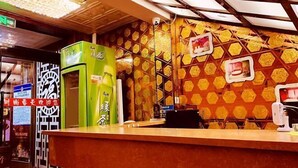 A restaurant interior with a counter, green beverage dispensers, and a patterned wall. - Suihua Fashion Spring Express Hotel (Suihua)