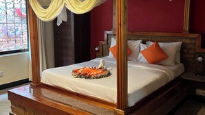 Un letto a baldacchino con baldacchino, una piattaforma in legno e un vassoio decorativo sul letto.