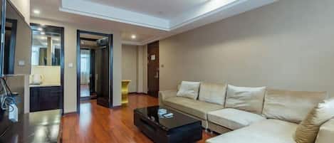 A modern living room with a sofa, coffee table, and a TV on a stand.