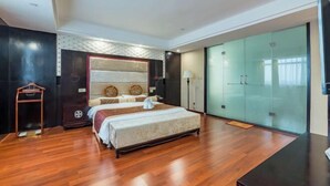 Una habitación de hotel moderna con una cama grande, un armario y un ventanal que da a un balcón.