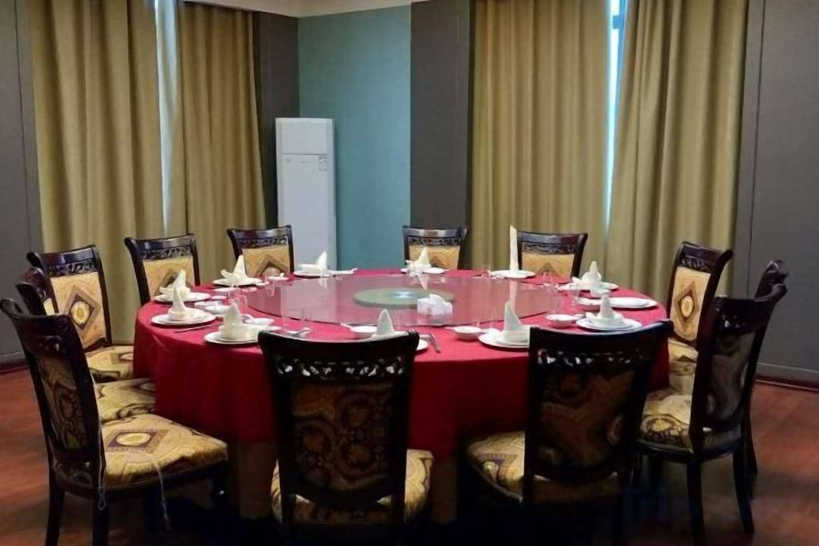 A conference room with a round table, chairs, and a whiteboard.