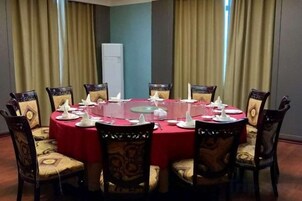 Un salón de conferencias con una mesa redonda, sillas y una pizarra.