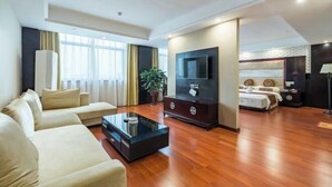 Una sala de estar moderna con un conjunto de sofás, un televisor de pantalla plana, una mesa de centro y una planta en maceta.