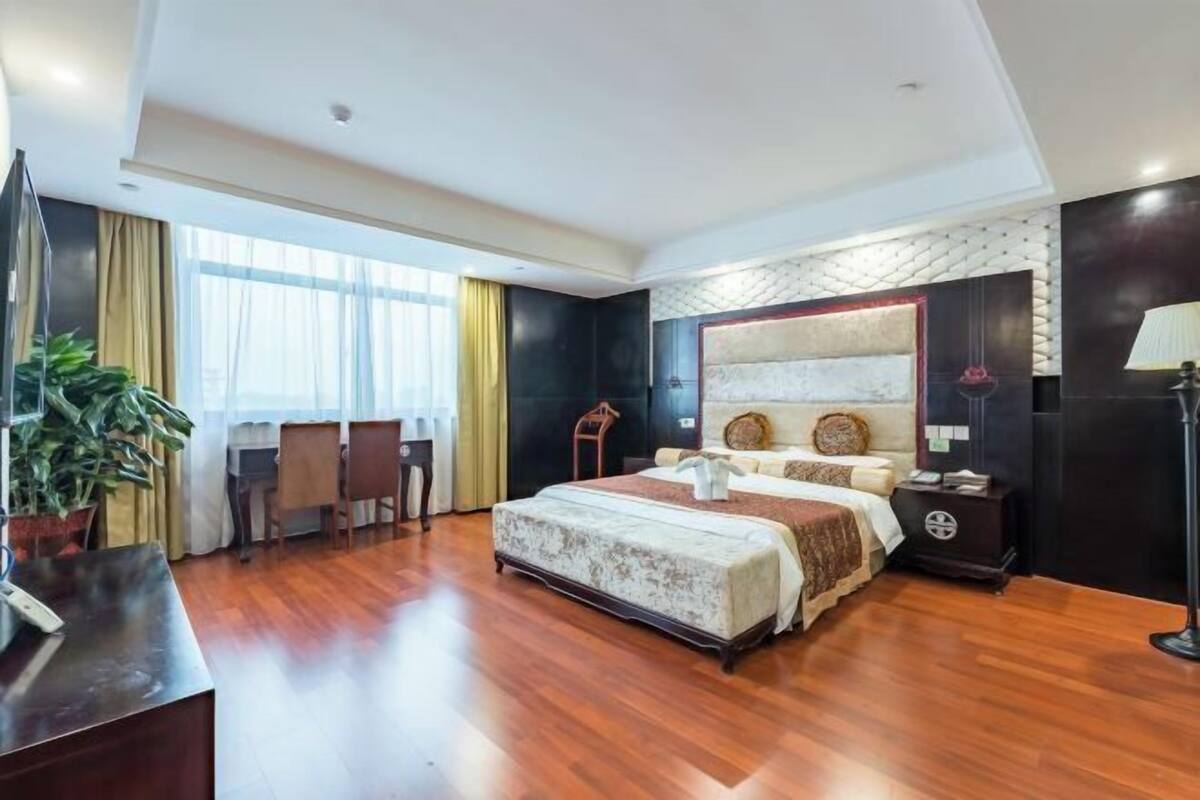 Una habitación de hotel espaciosa con una cama grande, un escritorio y una silla.
