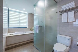 Une salle de bain moderne avec une douche à parois de verre, des toilettes blanches et une baignoire.